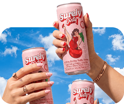 Hands holding three Surely Dirty cherry drink cans.